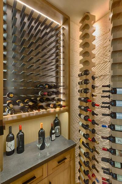 Custom wine cellar with backlit metal racks and stone wall