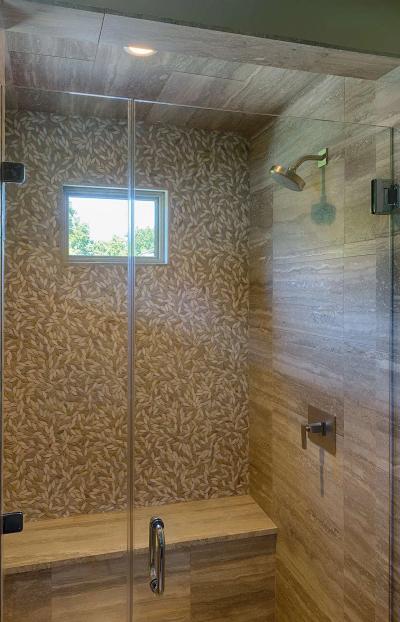 Master shower with travertine and leaf-mosaic feature wall