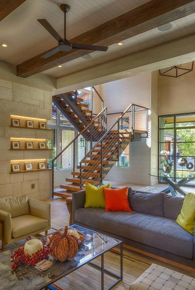 Living room opens to a floating wood-and-steel staircase