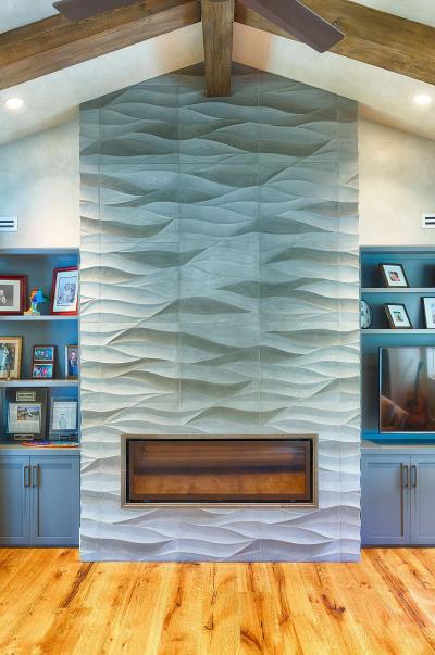 Sculpted wave-tile fireplace wall with custom built-ins