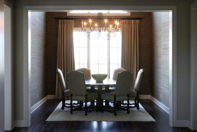 Formal dining room framed by grasscloth walls and a beaded chandelier