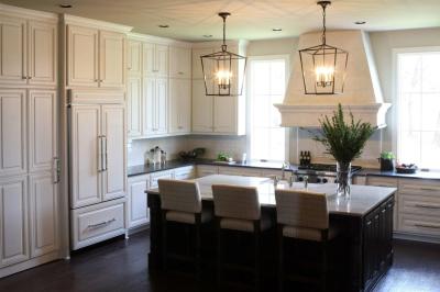Wide view of the kitchen with island seating and limestone hood