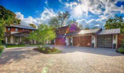 Approach to the wood and limestone garage wing under live oaks